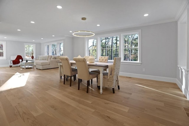 dining room with light hardwood / wood-style flooring and ornamental molding