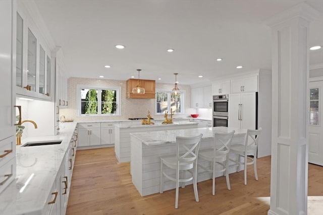 kitchen featuring white cabinets, a kitchen island, sink, and appliances with stainless steel finishes