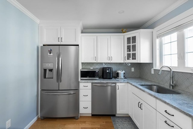 27 Mill St Unit B, Quincy, MA 02169 - kitchen featuring stainless steel appliances, a sink, tasteful backsplash, ornamental molding, and light wood-type flooring