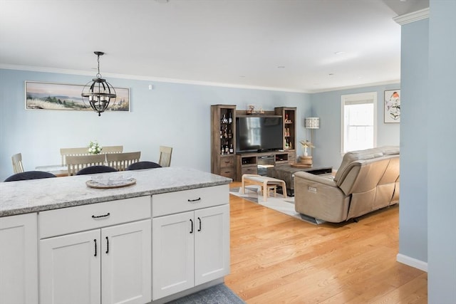 27 Mill St Unit B, Quincy, MA 02169 - kitchen with light wood-style flooring, white cabinetry, crown molding, hanging light fixtures, and open floor plan