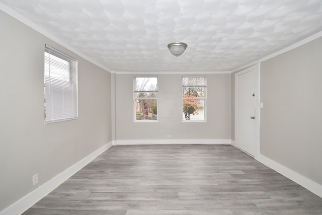 empty room featuring light hardwood / wood-style floors and crown molding