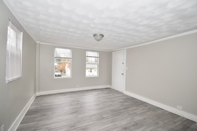 empty room featuring hardwood / wood-style flooring and ornamental molding