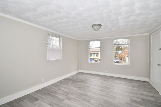 empty room with light hardwood / wood-style flooring and ornamental molding