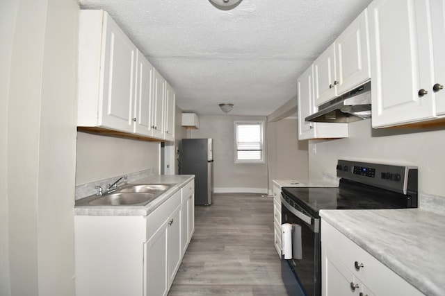 kitchen featuring white cabinets, light wood-type flooring, sink, and appliances with stainless steel finishes