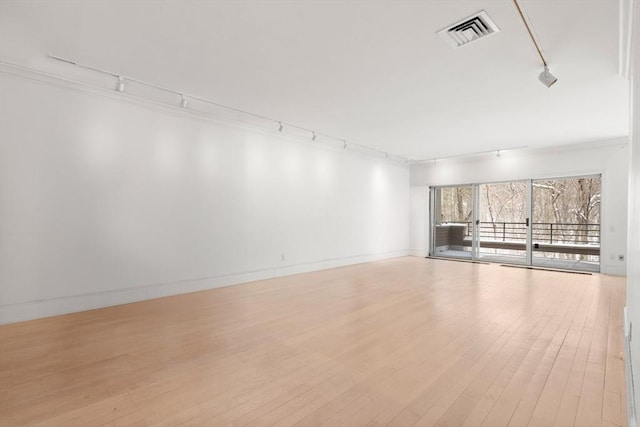 interior space featuring crown molding, light wood finished floors, visible vents, track lighting, and baseboards