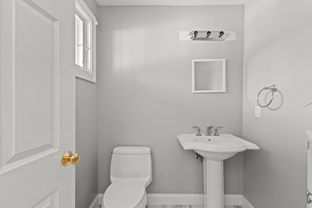 bathroom featuring toilet and baseboards