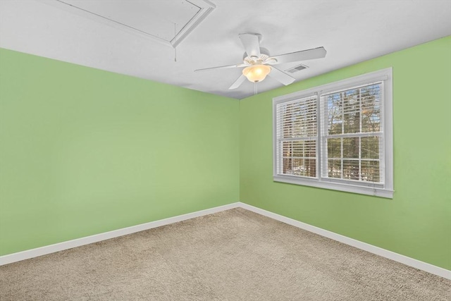 spare room with visible vents, carpet floors, attic access, and baseboards