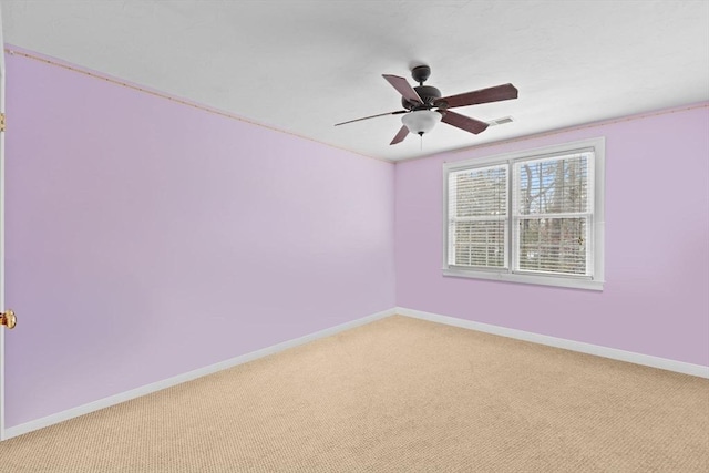 carpeted empty room with a ceiling fan, visible vents, and baseboards