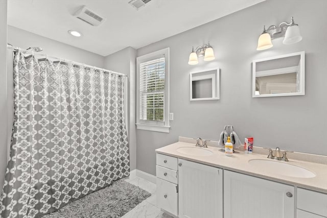 bathroom featuring marble finish floor, double vanity, a sink, and visible vents