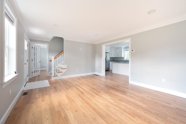 18 Tispaquin St, Middleboro, MA 02346 - unfurnished living room with ornamental molding, light wood finished floors, baseboards, and stairway
