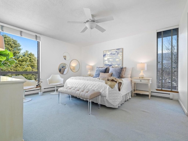 bedroom with multiple windows, carpet, and baseboard heating