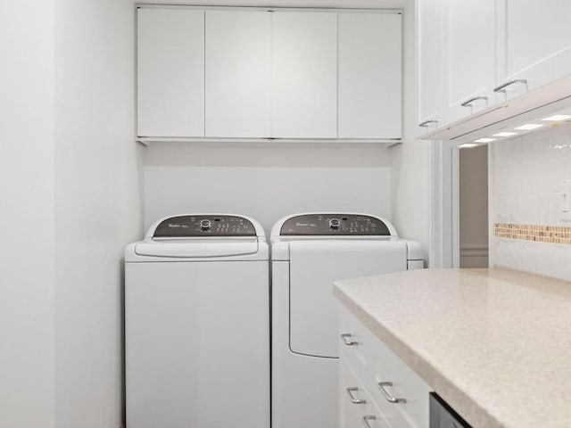 washroom with separate washer and dryer and cabinets