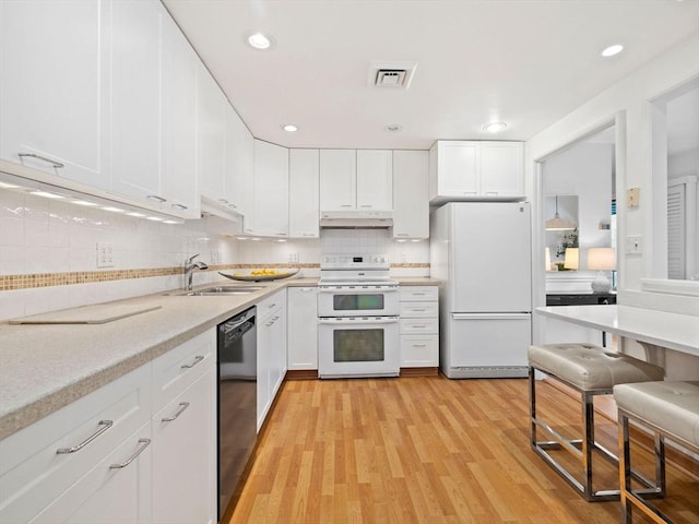 kitchen featuring white appliances, sink, light hardwood / wood-style flooring, and white cabinets