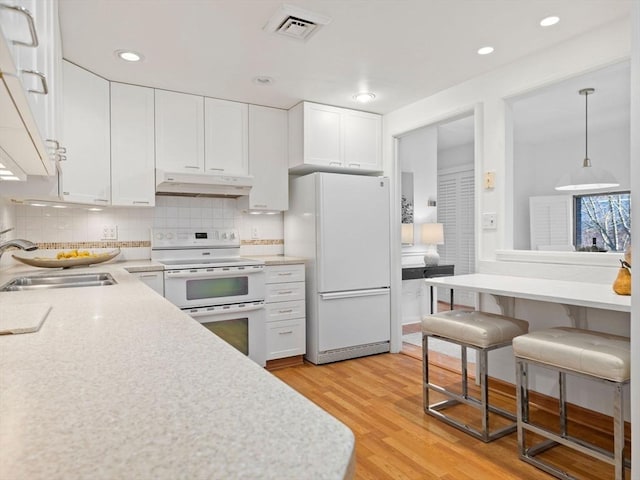 kitchen with white cabinetry, sink, and white appliances