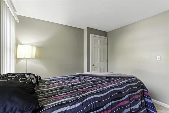 bedroom featuring baseboards and carpet