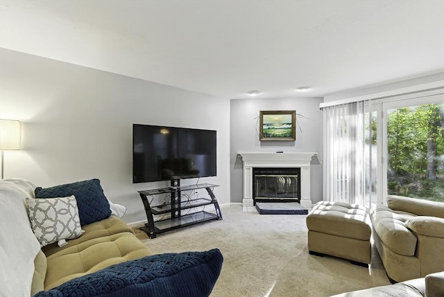 living area featuring light carpet, baseboards, and a glass covered fireplace