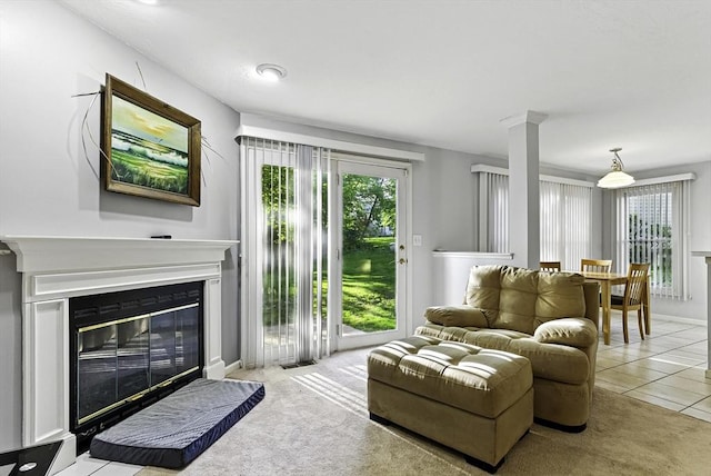 living area with a glass covered fireplace and light tile patterned floors