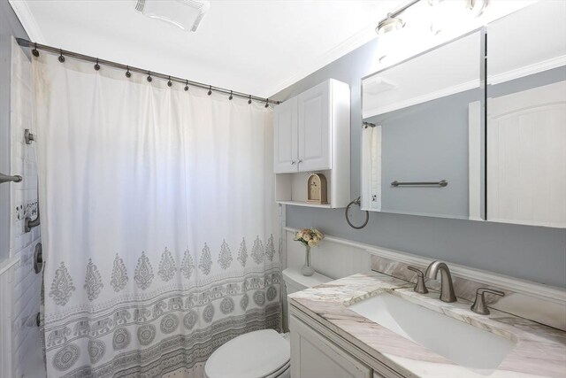 full bath featuring toilet, ornamental molding, vanity, and a shower with curtain