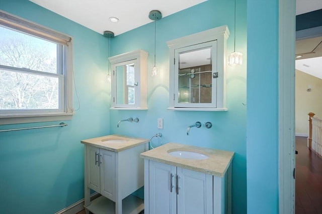 bathroom featuring two vanities and baseboards