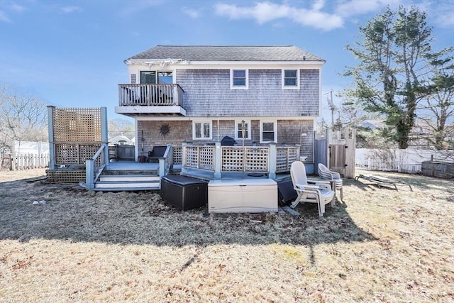 back of house with fence, a balcony, and a deck