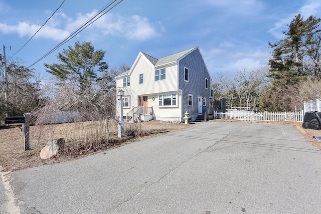 view of front of house featuring fence and uncovered parking