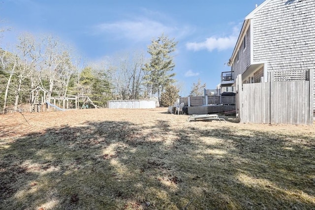 view of yard featuring a deck and a playground