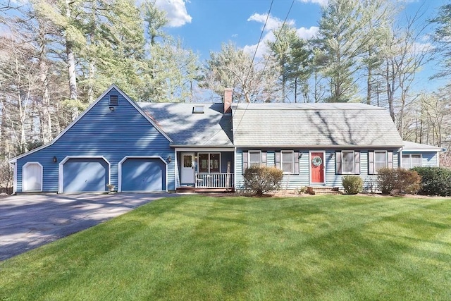 view of front facade with a porch, a front yard, a chimney, a garage, and driveway