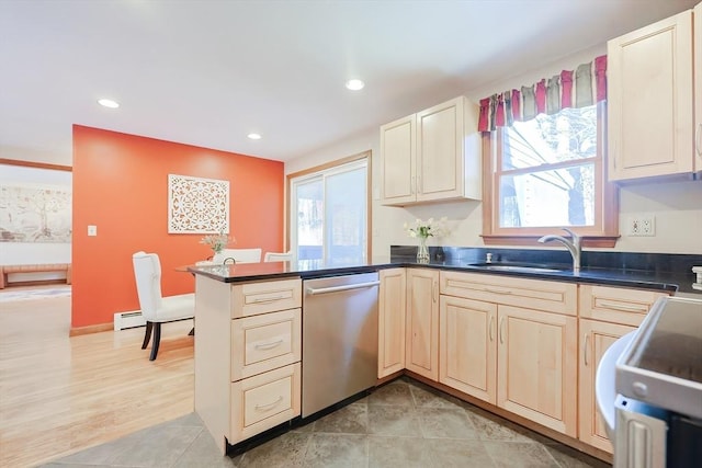 kitchen with a sink, plenty of natural light, stainless steel dishwasher, and a peninsula