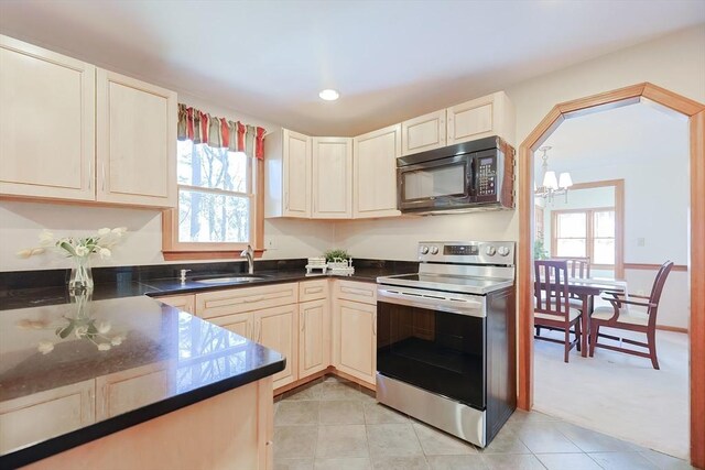 kitchen with plenty of natural light, stainless steel electric range oven, black microwave, and a sink