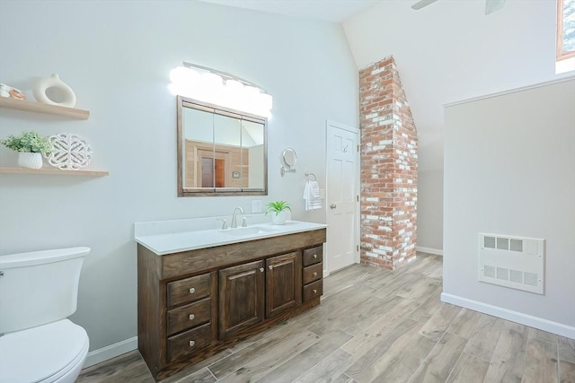 bathroom featuring visible vents, toilet, wood finished floors, baseboards, and vanity