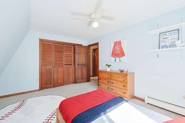 bedroom featuring light carpet, ceiling fan, a baseboard heating unit, and a closet