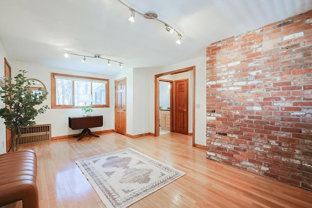 interior space featuring baseboards, light wood-style floors, and track lighting