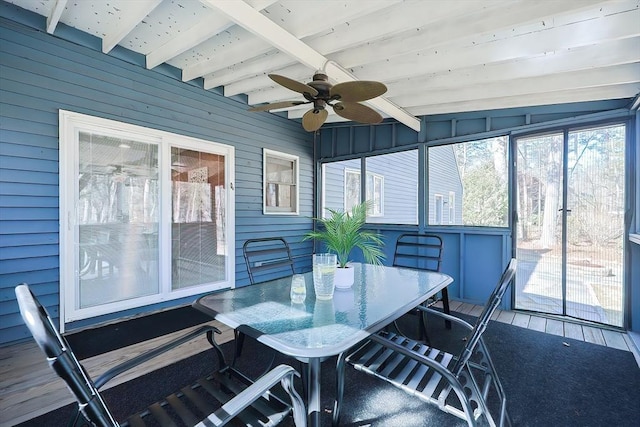 sunroom / solarium featuring beam ceiling and a ceiling fan