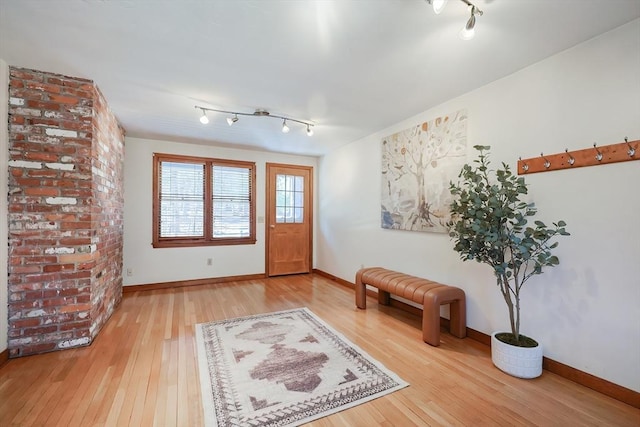 foyer with track lighting, baseboards, and hardwood / wood-style floors