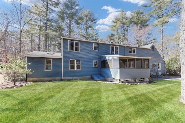 back of property with a lawn and a sunroom