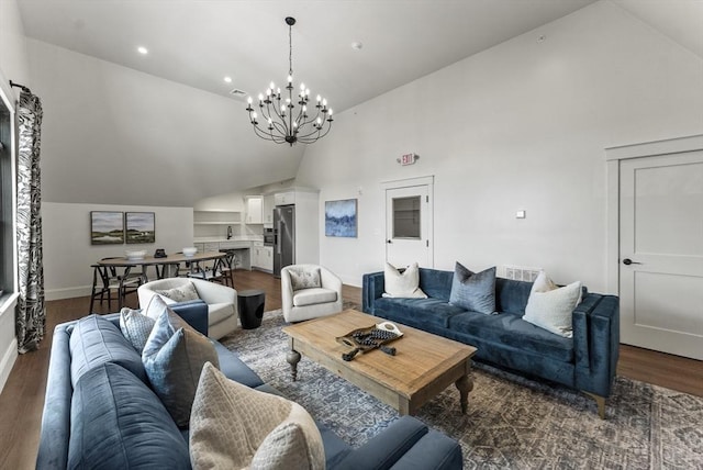 living room featuring a notable chandelier, dark wood-type flooring, high vaulted ceiling, and sink