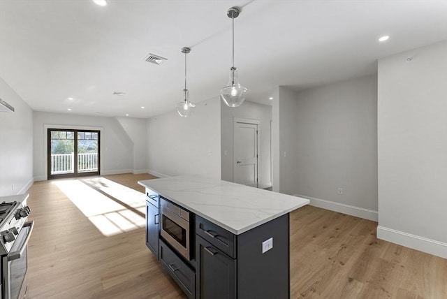 kitchen with decorative light fixtures, light wood-type flooring, a center island, and appliances with stainless steel finishes