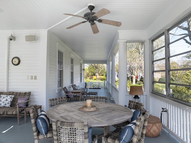 sunroom / solarium with a ceiling fan, plenty of natural light, and outdoor dining space