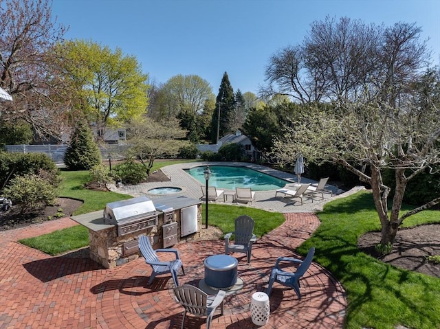 view of pool featuring an outdoor kitchen, area for grilling, a patio, and a lawn