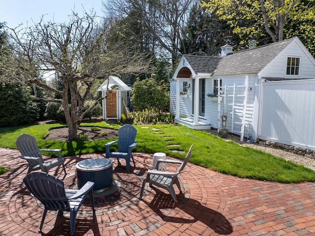 view of patio with an outdoor fire pit and an outdoor structure