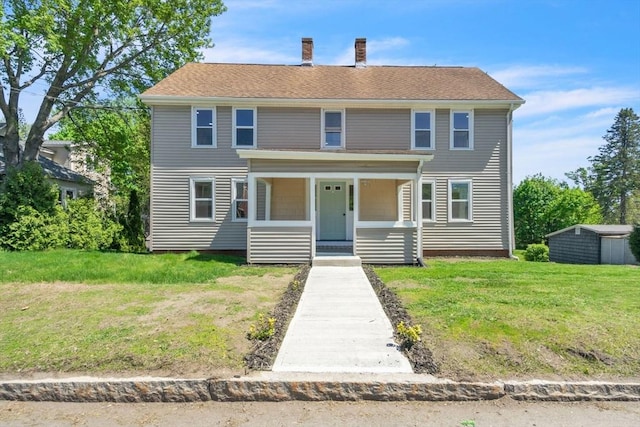 view of front of home featuring a porch, a chimney, and a front lawn