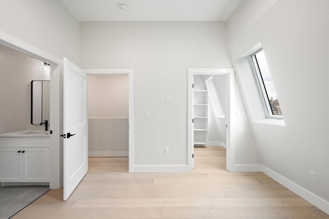 21 Ashland Unit 21, Boston, MA 02122 - unfurnished bedroom with light wood-type flooring, a spacious closet, and baseboards