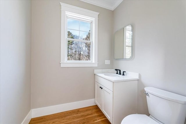 bathroom with plenty of natural light, toilet, crown molding, and vanity