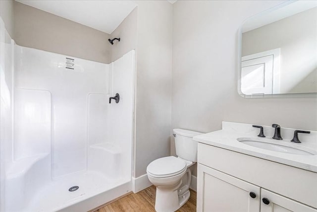 bathroom with hardwood / wood-style floors, vanity, toilet, and walk in shower