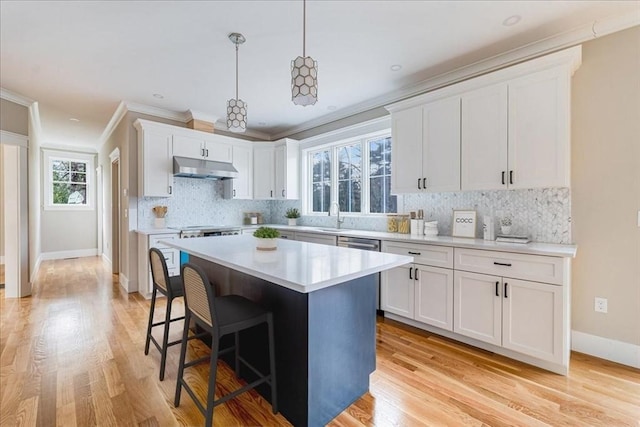 kitchen featuring white cabinets, pendant lighting, light hardwood / wood-style floors, and a kitchen island