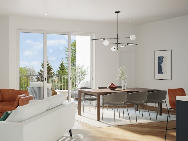 dining area with light wood-type flooring and a notable chandelier