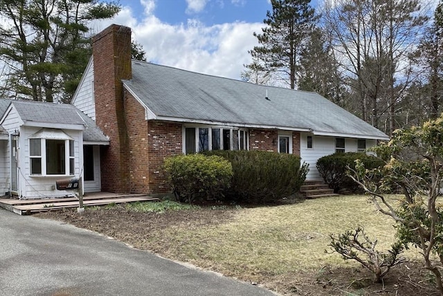 101 Highfields Rd, Abington, MA 02351 - view of front of home with a chimney, brick siding, a front lawn, and roof with shingles