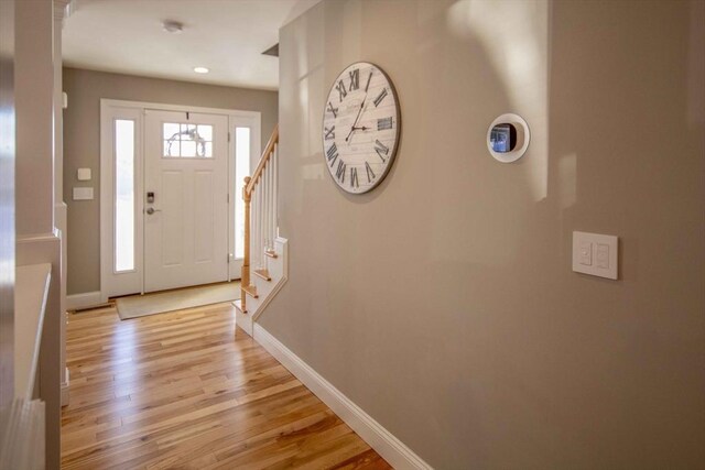 entrance foyer with stairs, light wood finished floors, recessed lighting, and baseboards