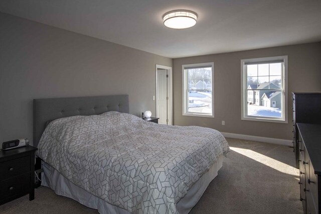 bedroom with light carpet and baseboards