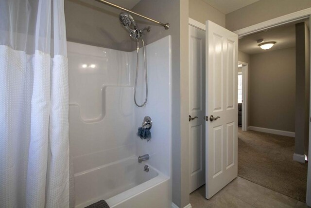 bathroom featuring shower / tub combo, tile patterned flooring, and baseboards